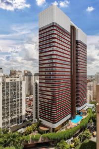 a tall building with a pool in front of a city at Renaissance São Paulo Hotel in São Paulo