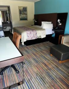 una habitación de hotel con 2 camas y una silla en Discovery Inn Lafayette en Lafayette