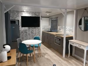 a kitchen with a table and chairs and a tv at Domaine bulle étoilée in Rouilly-Sacey