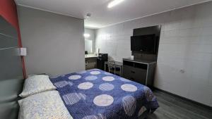 a bedroom with a bed and a kitchen and a television at Sheridan Inn in Sheridan