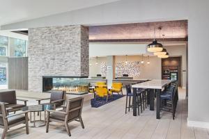 伯克利Residence Inn By Marriott Berkeley的一间带桌椅和壁炉的用餐室