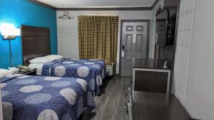 ein Hotelzimmer mit 2 Betten und einem TV in der Unterkunft Sheridan Inn in Sheridan