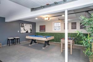a room with a pool table and some plants at Beautiful Modern Farmhouse Style Mins 2 Beach, Winery, Casino, Shopping and More 