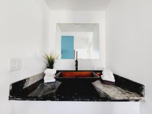 a bathroom with a red sink and a mirror at The West Gem in Miami Beach +186 photos
