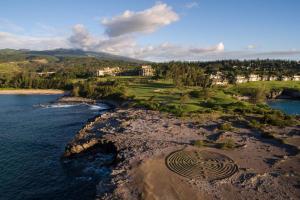 an aerial view of a golf course next to the water at The Ritz-Carlton Maui, Kapalua in Lahaina