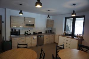 a kitchen with wooden cabinets and a table and chairs at Powidok in Wetlina