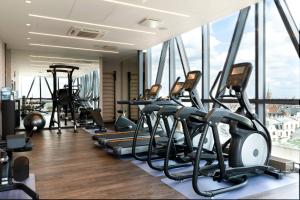 a gym with rows of treadmills and elliptical machines at AC Hotel by Marriott Riga in Riga