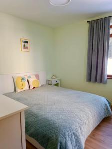 a bedroom with a bed with a blue comforter and a window at Lovely forest escape, Mountain Lake complex in Smolyan