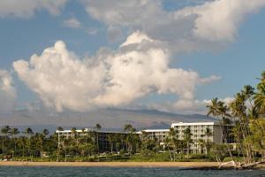 ein Resort am Strand mit Palmen und einem Gebäude in der Unterkunft Waikoloa Beach Marriott Resort & Spa in Waikoloa