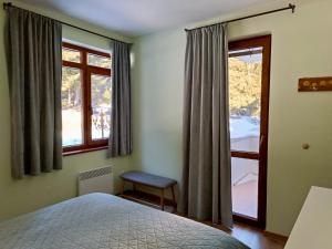 1 dormitorio con 1 cama y 2 ventanas en Lovely forest escape, Mountain Lake complex en Smolyan