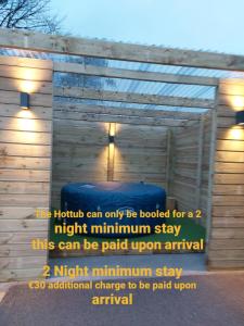 una pared con un cartel que diga que sólo se puede reservar una noche como mínimo en Luxurious Log Cabin with lay-z spa hot tub en Ballina