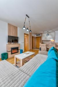 NEO Apartman في زلاتيبور: غرفة نوم مع سرير وغرفة معيشة