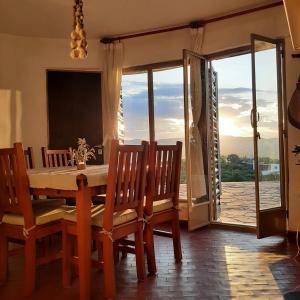 comedor con mesa, sillas y ventana en Mediterránea Casa Vacanza en Villa Carlos Paz