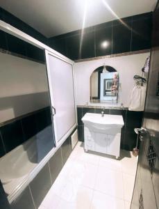 a bathroom with a tub and a sink and a mirror at Nice apartment in the city center in Marrakech