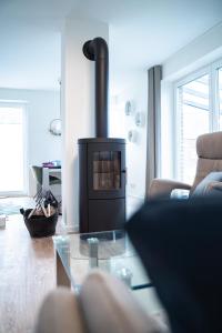 a living room with a wood stove in a room at Urlaub an der Nordsee - NEU - Ferienhaus Deichliebe in Fedderwarderdeich