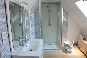 a white bathroom with a shower and a sink at Petite maison bretonne pour 4 personnes in Plounérin +15 photos