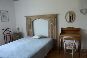 a bedroom with a bed and a desk and a chair at Petite maison bretonne pour 4 personnes in Plounérin
