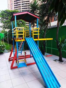 un parque infantil con un tobogán azul y amarillo en Apartamento Vista Mar - Beira Mar, en Fortaleza