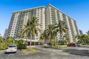 een groot gebouw met palmbomen op een parkeerplaats bij Ocean reserve On the Beach Best Location in Miami Beach