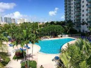 een groot zwembad met palmbomen en een gebouw bij Ocean reserve On the Beach Best Location in Miami Beach