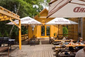 een patio met tafels, stoelen en parasols bij Forest Garden Family 