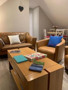 a living room with a table with books on it at Lily’s Loft Bushmills in Bushmills