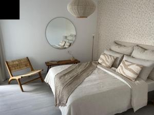 1 dormitorio con cama, espejo y silla en AD apartment, en La Oliva