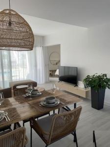 mesa de comedor con sillas y TV en AD apartment, en La Oliva