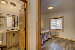 Alpine Lodge Hotel في Cascade: غرفة نوم بسرير ومغسلة ومرآة