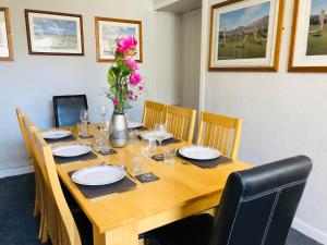uma mesa de madeira com pratos e um vaso de flores em Bonnygate em Fife