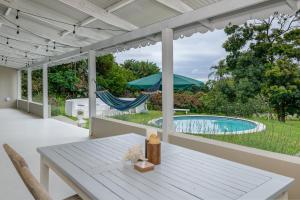 a patio with a table and a hammock and a pool at Golf Beach and Sea in Southbroom