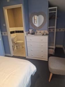 a bedroom with a bed and a sink and a mirror at The Sands Hotel in Paignton
