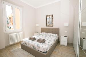 ein weißes Schlafzimmer mit einem Bett und einem Spiegel in der Unterkunft Maspes house in Santa Margherita Ligure