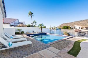 a swimming pool with two white chairs next to a house at Waterside - Lavish Lakeside Property with Heated Pool and Pontoon Boat in Peoria