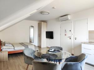 ein Wohnzimmer mit einem Tisch, Stühlen und einem Bett in der Unterkunft Dali Apartment Szentendre in Szentendre