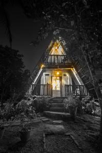 uma pequena casa com uma porta da frente iluminada à noite em villa ovita em Talpe