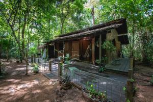 una cabaña en el bosque con una valla alrededor en Bangalô Ponta de Areia, na beira da praia, en Alter do Chao