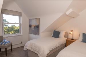 a bedroom with two beds and a window at Larkrise Penthouse Apartment in Woolacombe