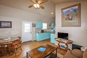 a living room with a table and a kitchen with blue cabinets at Palo Duro Canyon Texas - Cowboy Cabin in Canyon