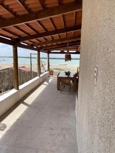 a patio with a table and a view of the beach at Casa Refúgio in Galinhos