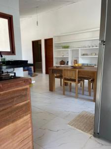 a kitchen with a table and a dining room at Casa Refúgio in Galinhos