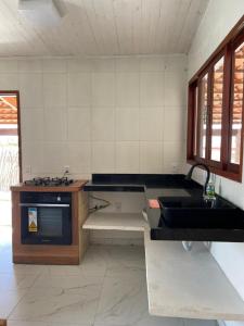 a kitchen with a sink and a stove at Casa Refúgio in Galinhos