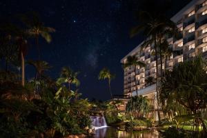 um hotel com cascata e palmeiras à noite em The Westin Maui Resort & Spa, Ka'anapali em Lahaina