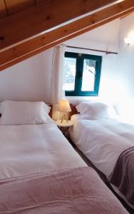 two beds sitting next to each other in a room at Kristi's Homes - "Beautiful Attic" in Dimitsana in Dhimitsana