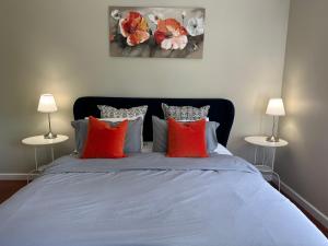 a bedroom with a bed with red pillows at Growse House Yarram 3BR in Yarram