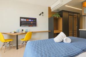 a bedroom with a blue bed and a table and chairs at Loft de Luxo no Bairro mais nobre de Goiânia in Goiânia