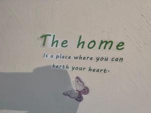 a butterfly on a wall with the words the home is a place where you can at 3 Bedroom House with Garden in Buckinghamshire