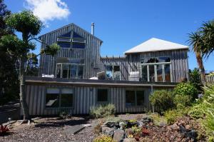 a large white house with a large window at Mangawhai Chalets in Mangawhai
