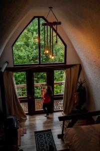 a woman sitting in a room with a large window at Căsuțele de sub Șipote in Porumbacu de Sus