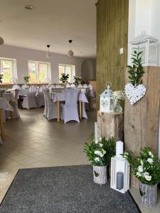 une salle à manger avec des tables blanches et des fleurs blanches dans l'établissement Pension Vyhlídka, à Klášterec nad Ohří